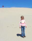 Summer with large sand dune behind her